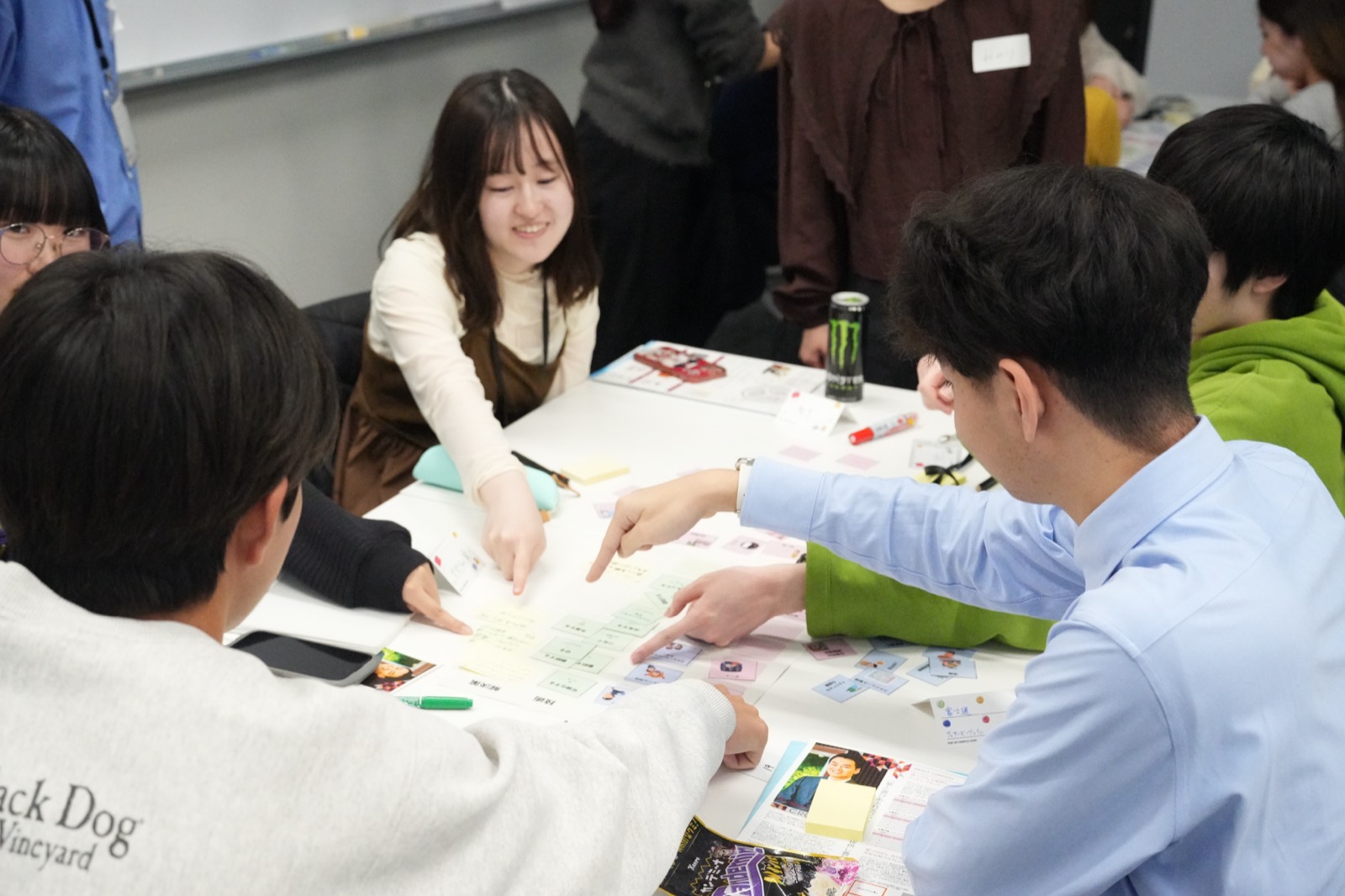 企業の社員と学生がテーブルを囲んで話し合っている様子